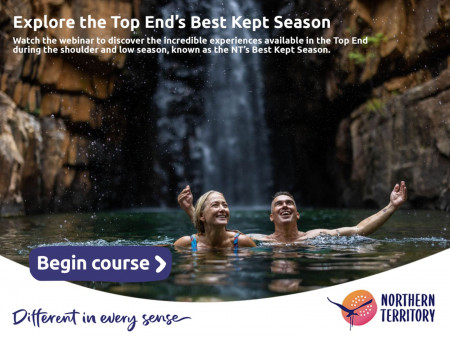 Man and woman swimming at the base of a waterfall